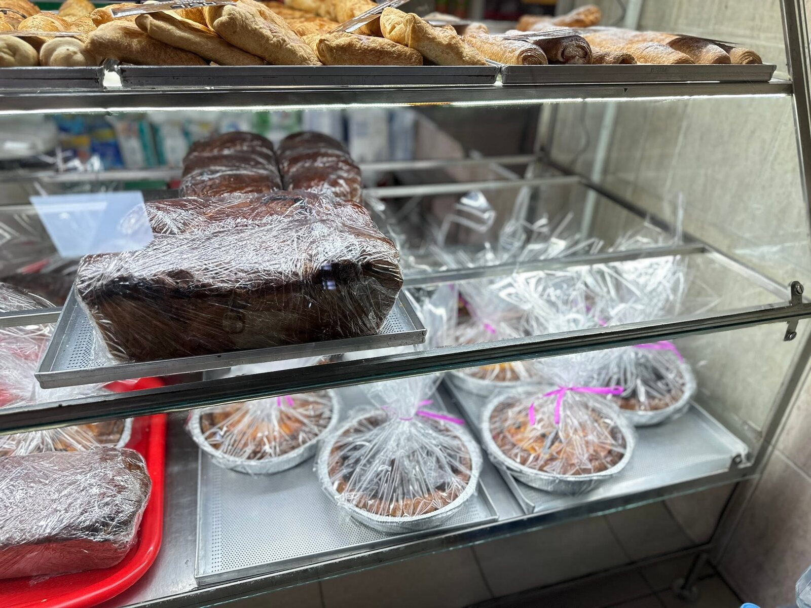 Vitrina cu foietaje, cozonaci ambalați și plăcinte la tavă
